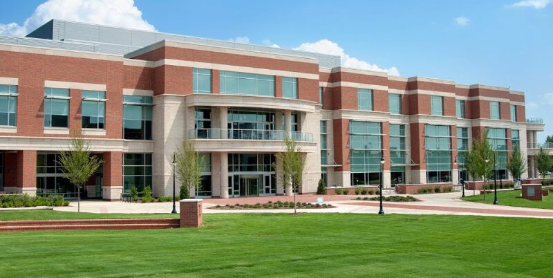 Modern brick campus building with green lawn